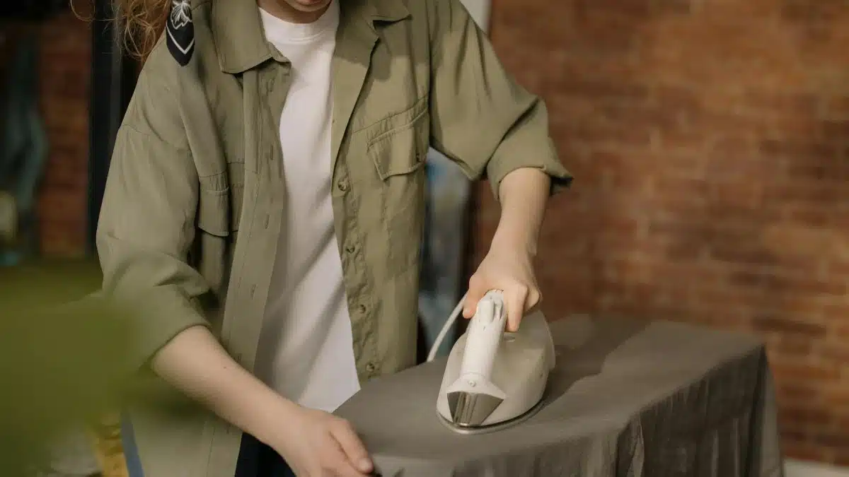 A young woman ironing clothes at home, emphasizing domestic tasks and cozy interior.