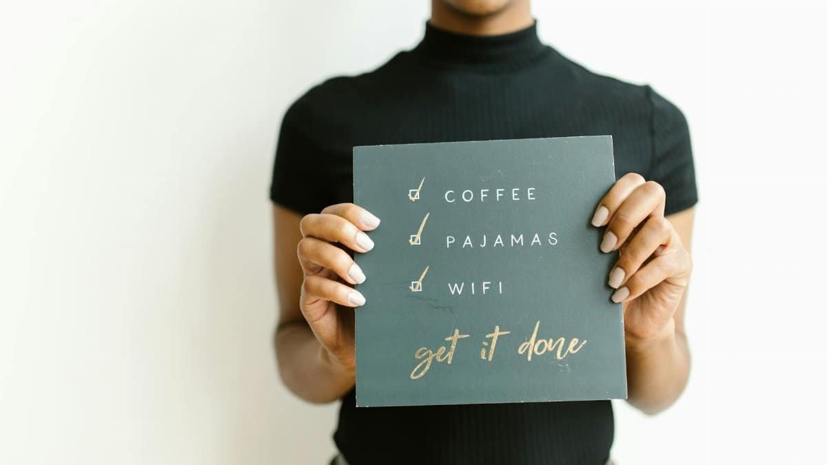 Woman holding a motivational checklist sign with simple tasks and goals.