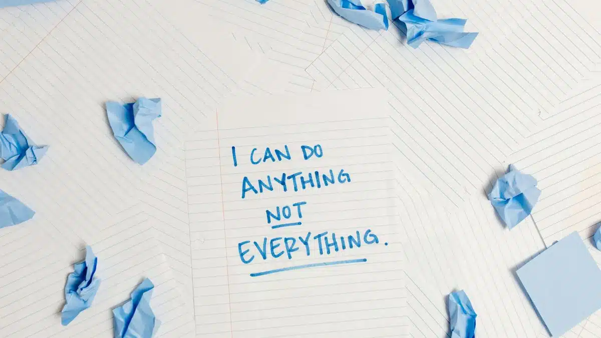 Inspirational message on a notepad surrounded by crumpled paper pieces.