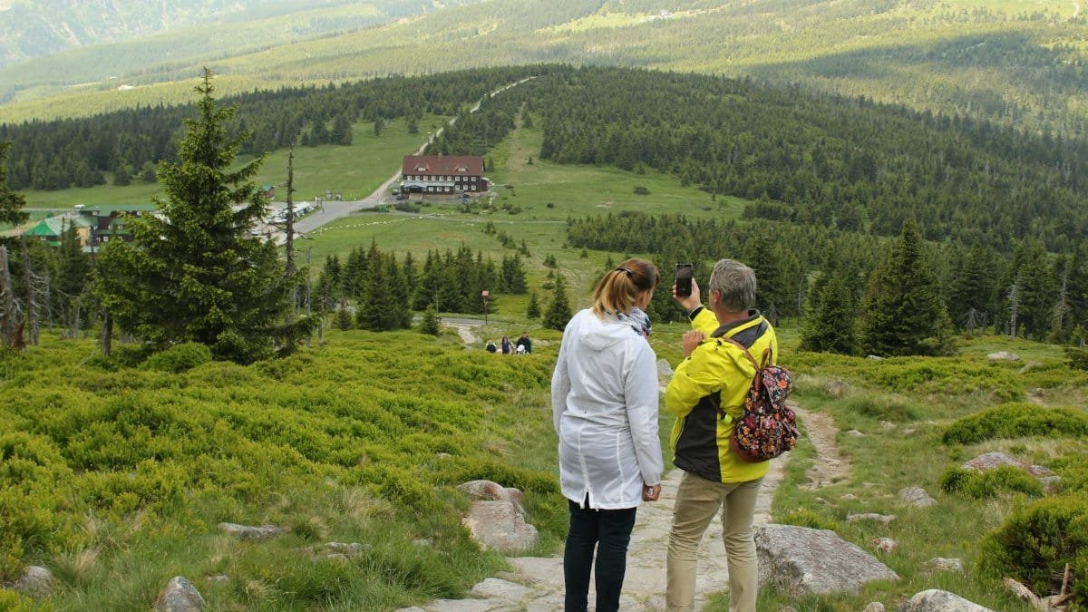 Couple hiking and capturing scenic views in Jelenia Góra, Poland.