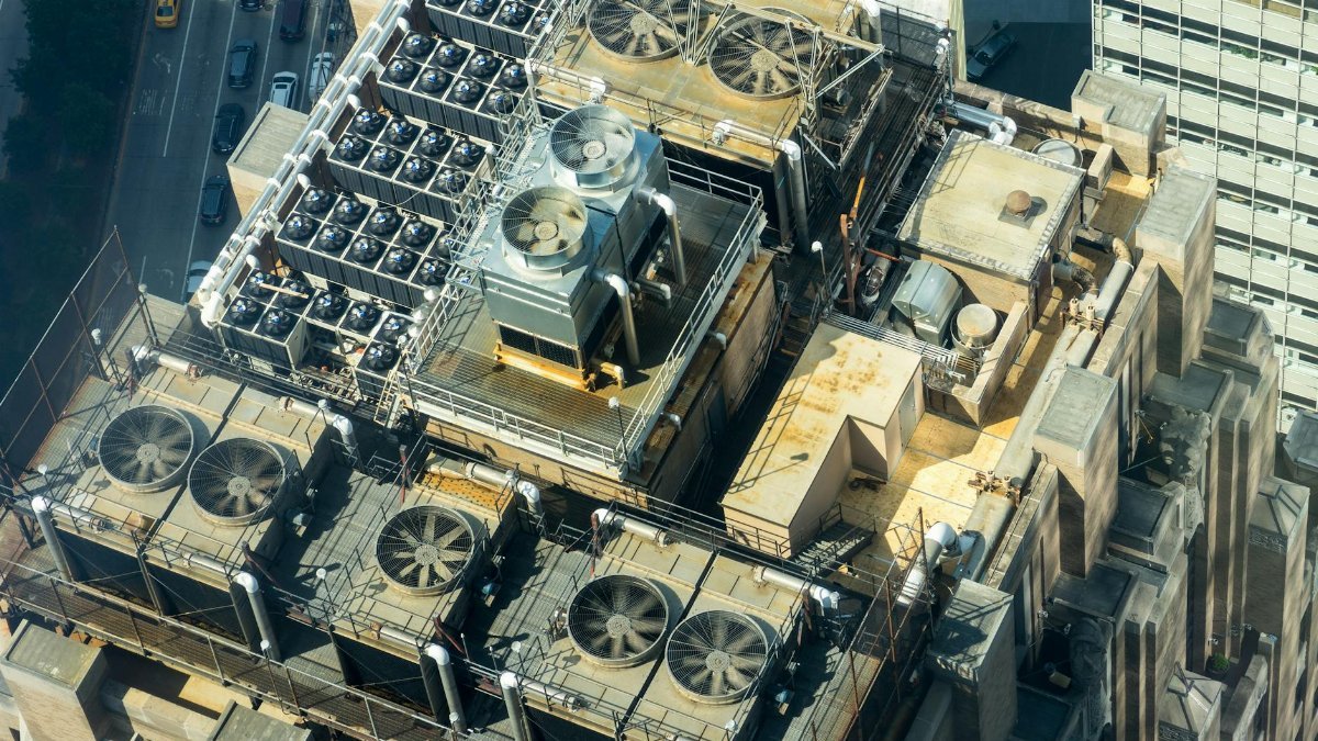 High-angle shot of HVAC units on a city building's rooftop, showcasing industrial infrastructure.