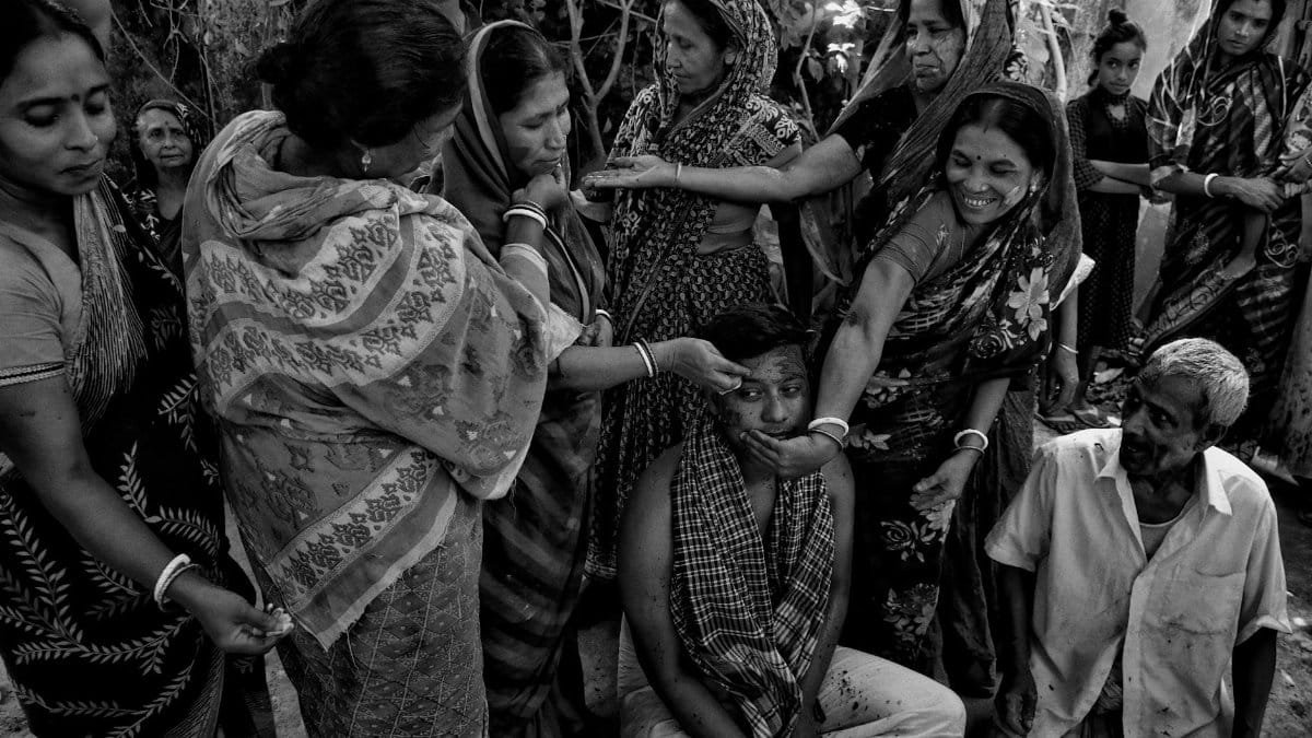 A black and white photo capturing a cultural Hindu ritual in a rural Indian village.
