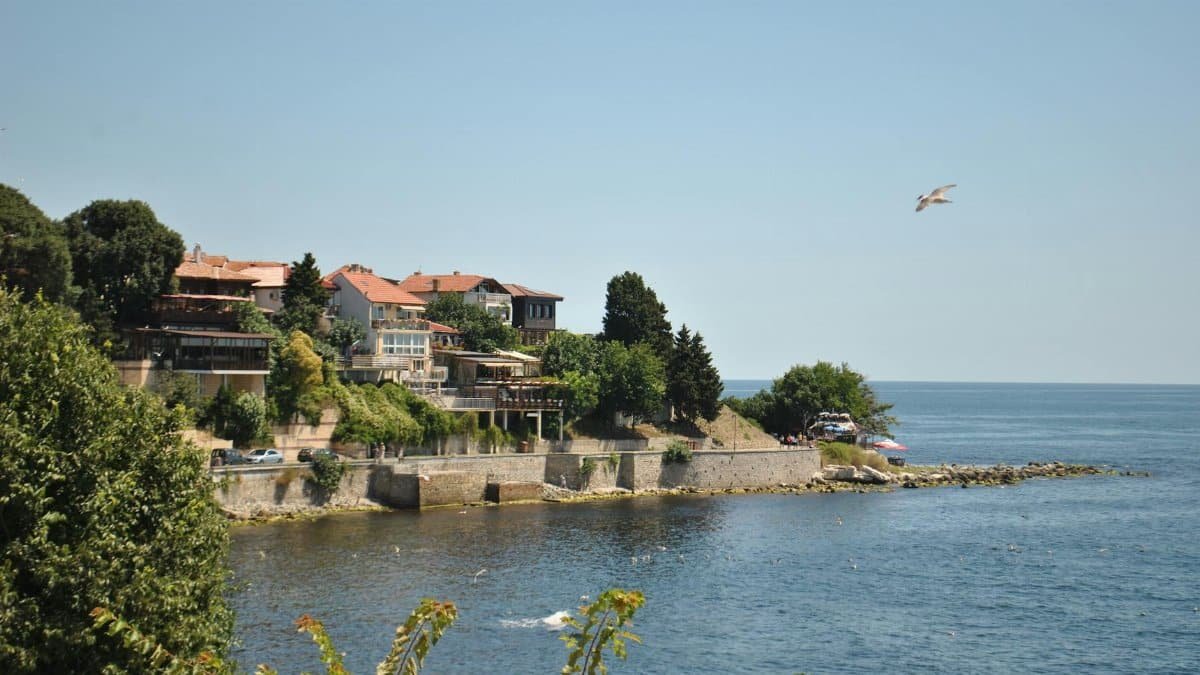 Picturesque cliffside view of a seaside village with clear blue ocean.