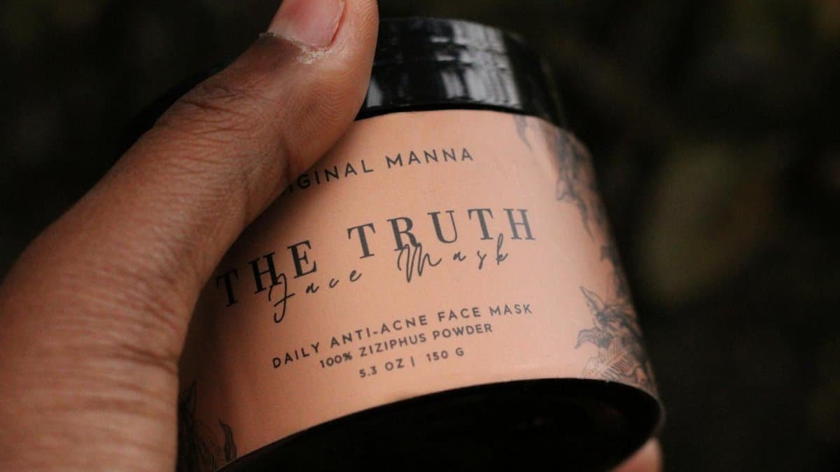 Close-up of hand holding 'The Truth' daily anti-acne face mask featuring Ziziphus powder.