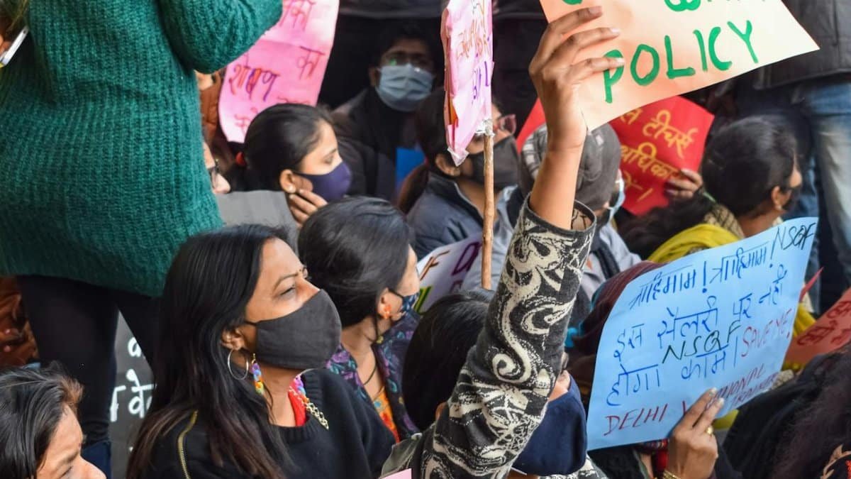 A crowd of protesters holding signs at a demonstration expressing their demands.