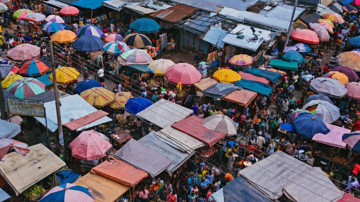 Vibrant aerial shot capturing the colorful stalls and bustling crowd of Aba market in Nigeria.