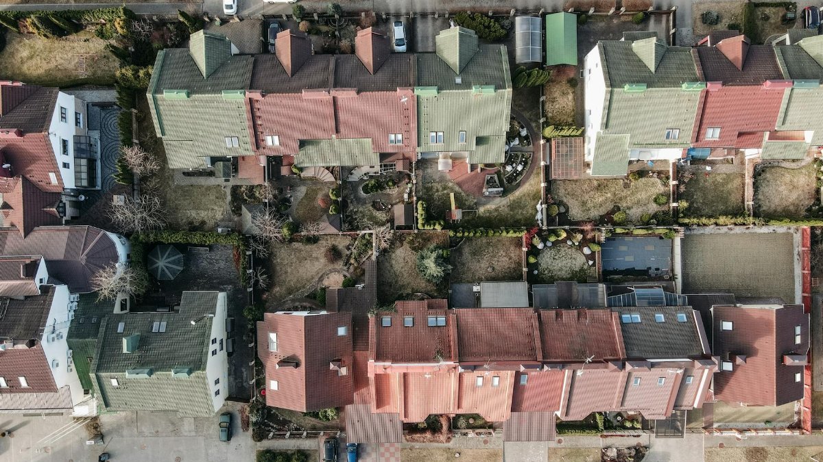 High-angle view of a suburban residential area with colorful rooftops and gardens.