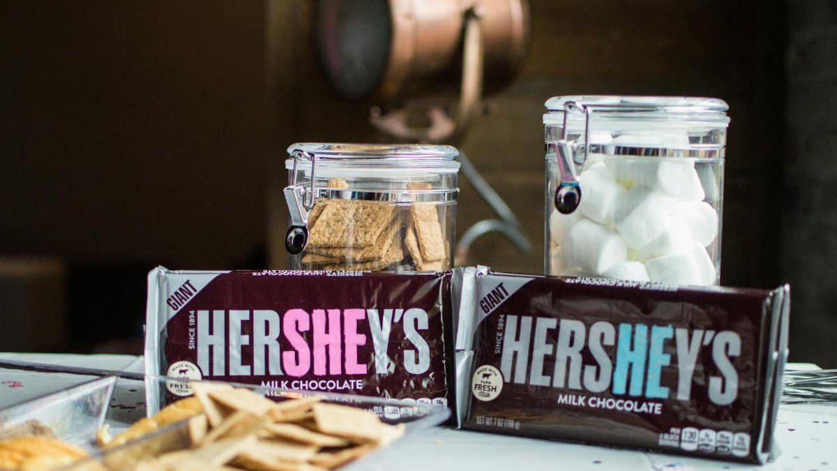 Close-up of Hershey's chocolate bars with jars of graham crackers and marshmallows for delicious s'mores.