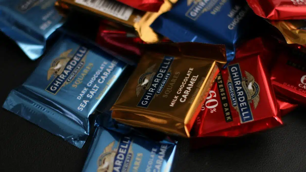 A close-up shot of a variety of Ghirardelli chocolate squares, including dark chocolate and milk chocolate caramel.
