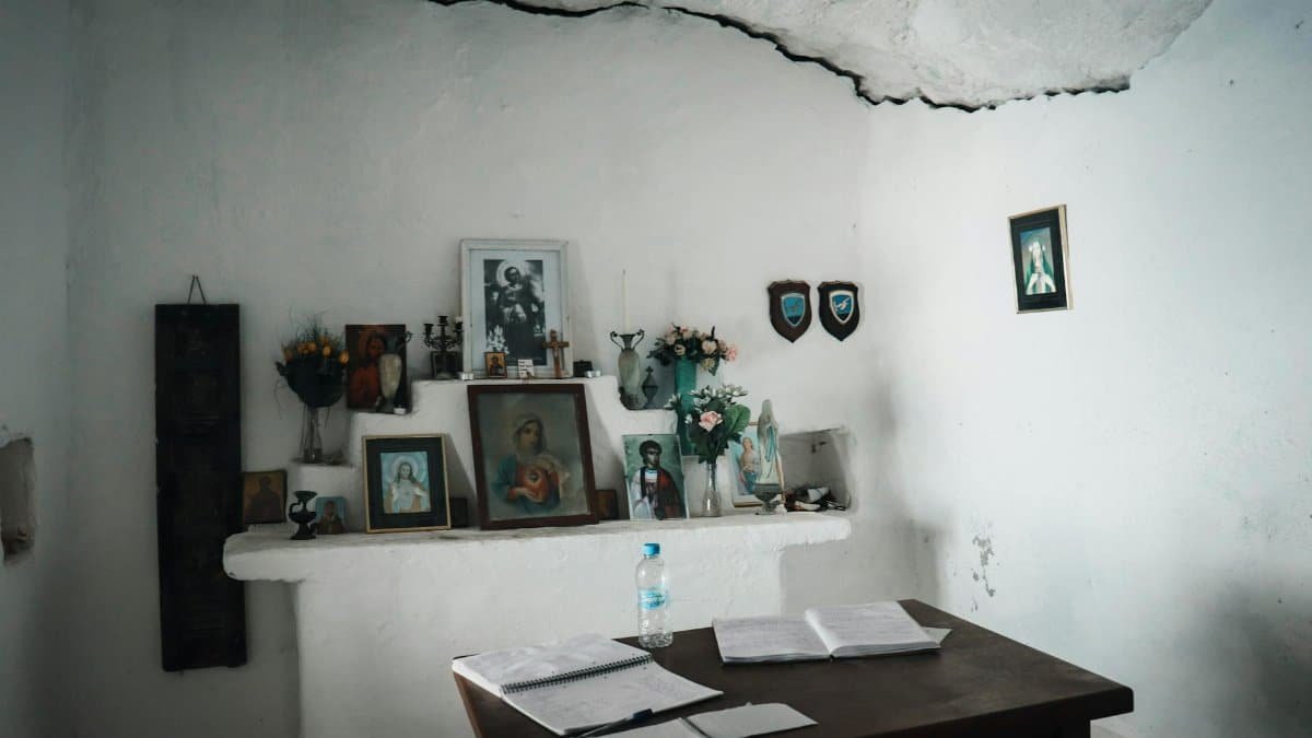 An intimate Greek home altar adorned with religious icons and floral decorations indoors.