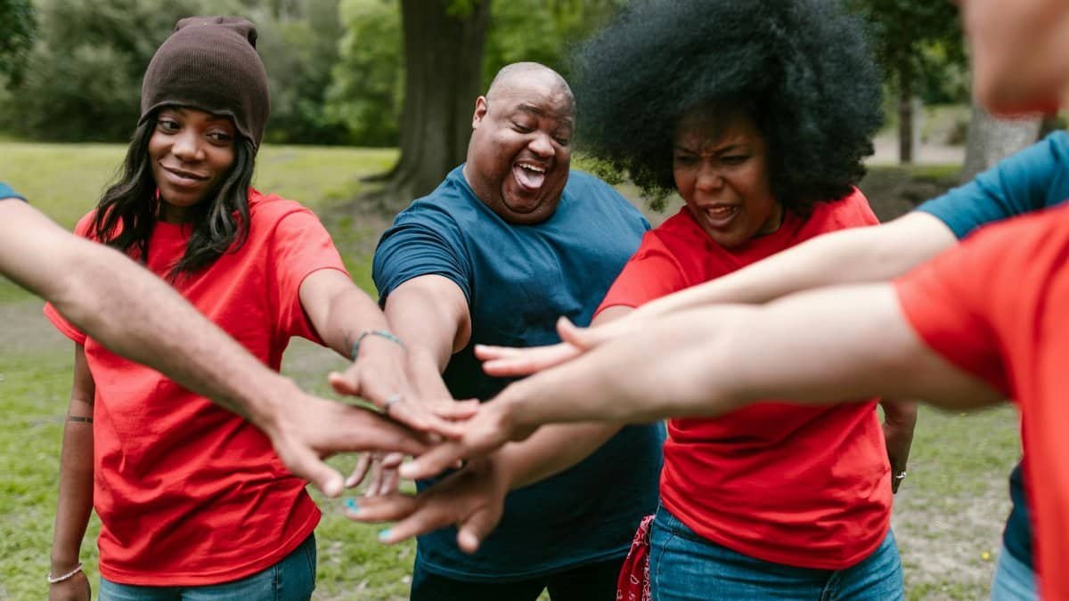 Diverse group of adults bonding during a team building activity outdoors.