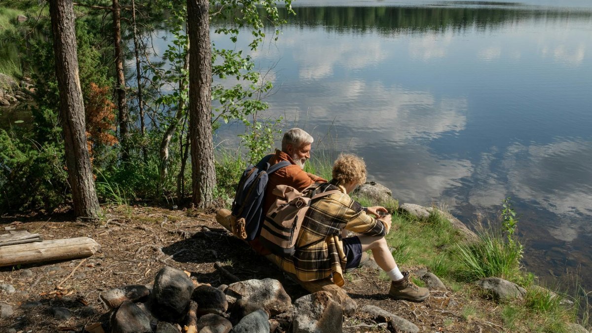 Grandfather and grandson enjoying a tranquil moment by a lakeside in nature.