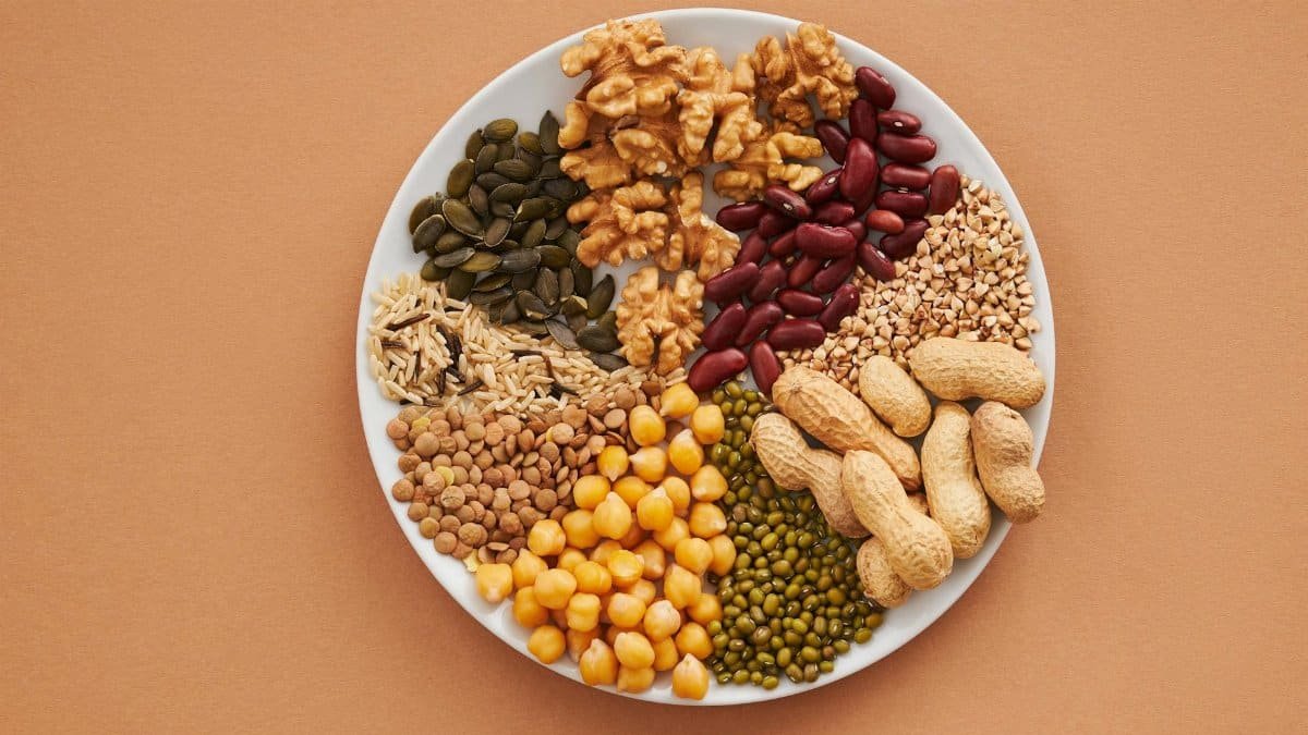 Top view of nuts, beans, and seeds on a plate, ideal for healthy dining themes.