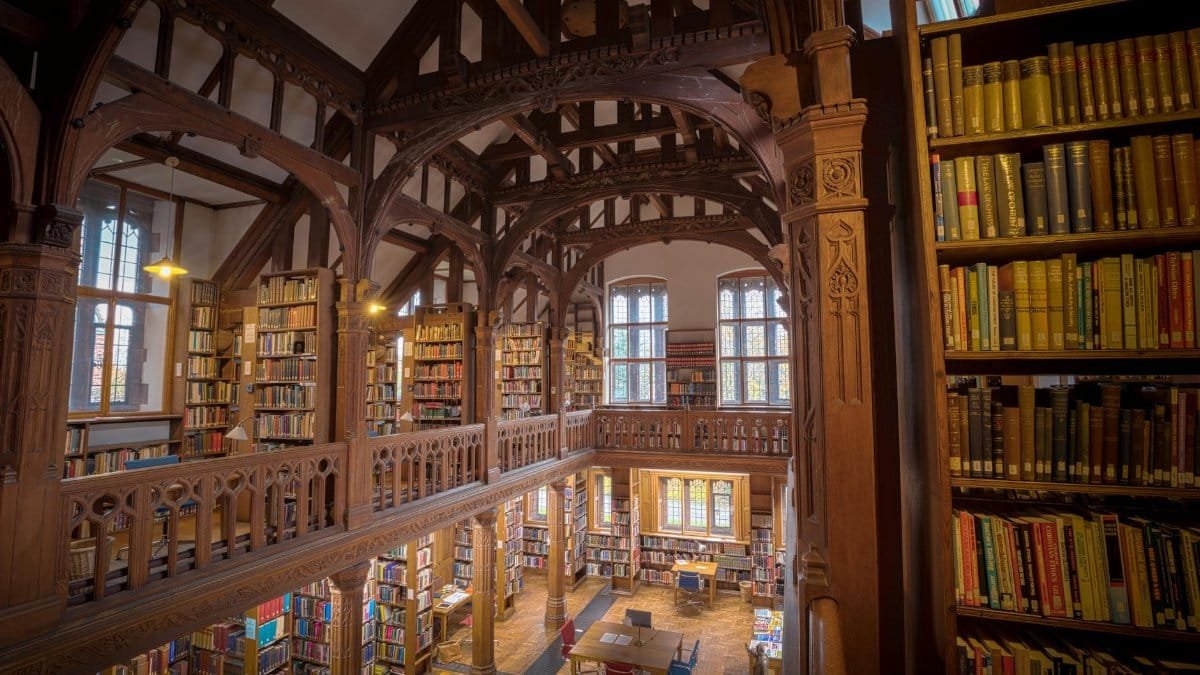Elegant interior of a historic library in Hawarden, showcasing wooden architecture and bookshelves.