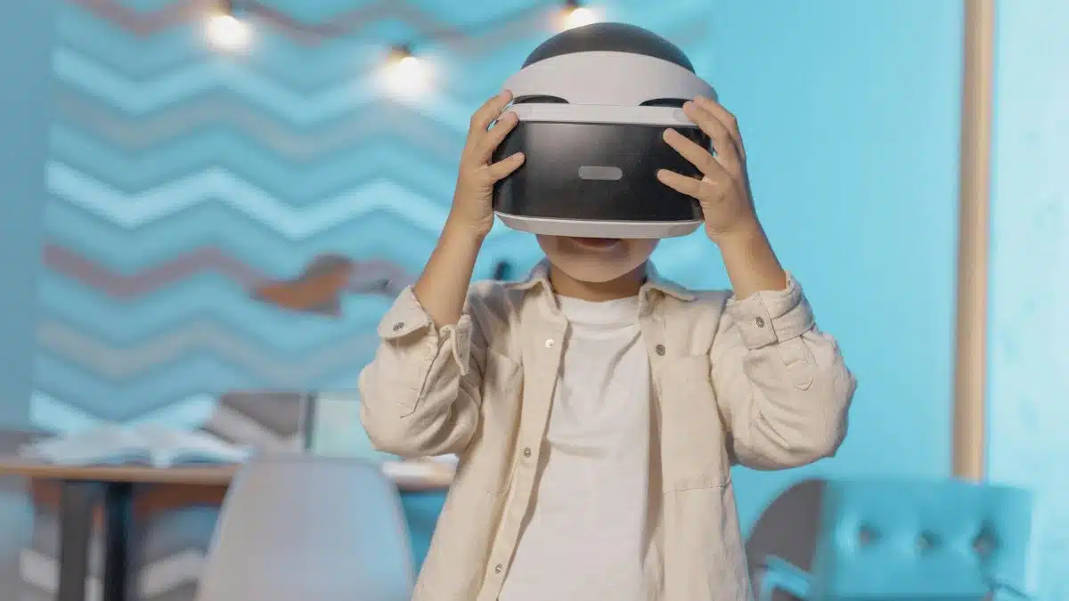 Young boy exploring virtual reality with VR goggles indoors, enjoying technology in a cozy setting.
