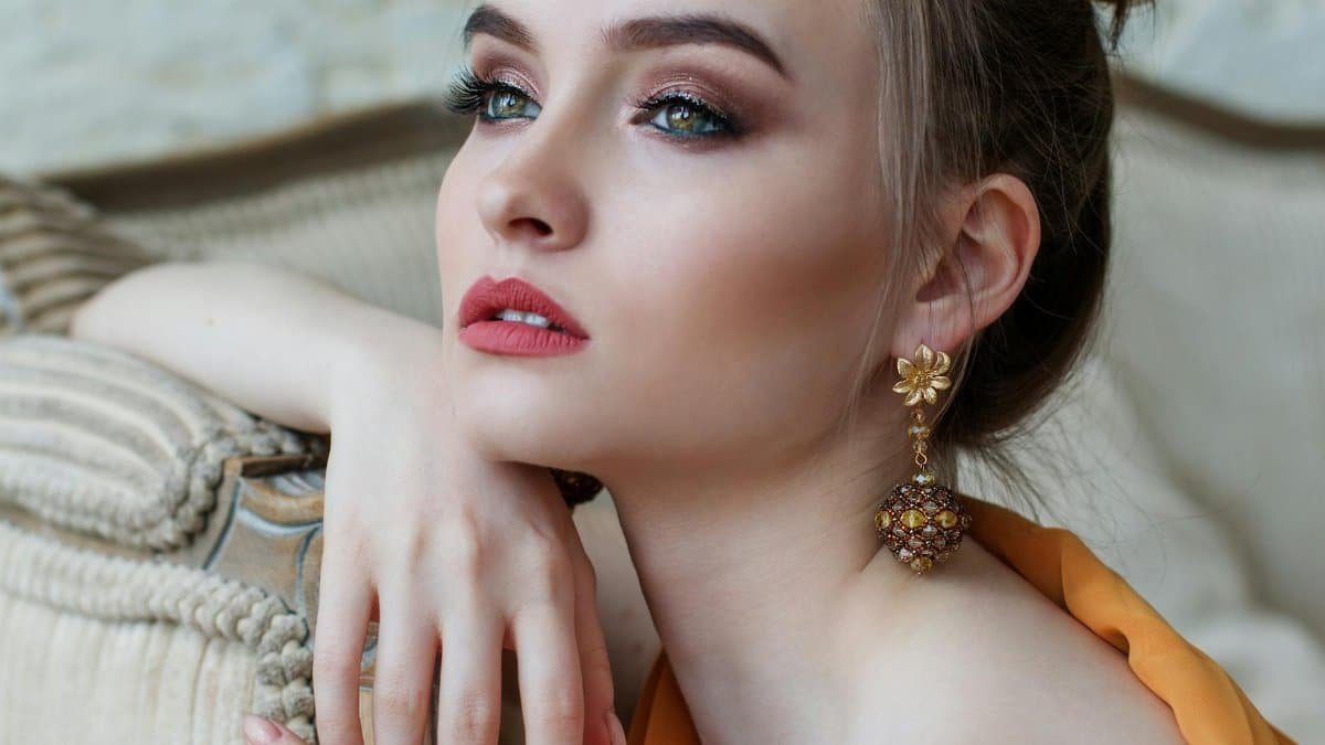 Stunning close-up portrait of a woman with elegant makeup and jewelry, epitomizing modern fashion and beauty.