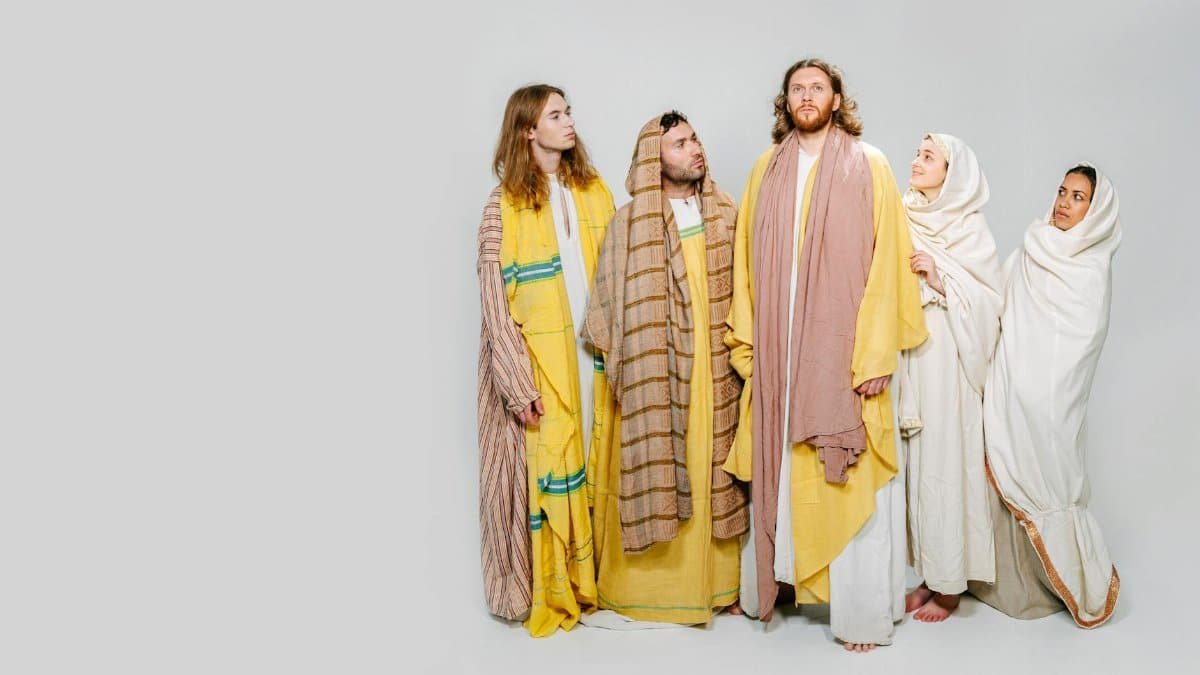 Five individuals in biblical attire pose against a white background, representing religious themes.