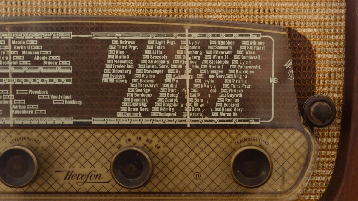 Close-up of a vintage radio displaying station names and frequency dial for a nostalgic effect.