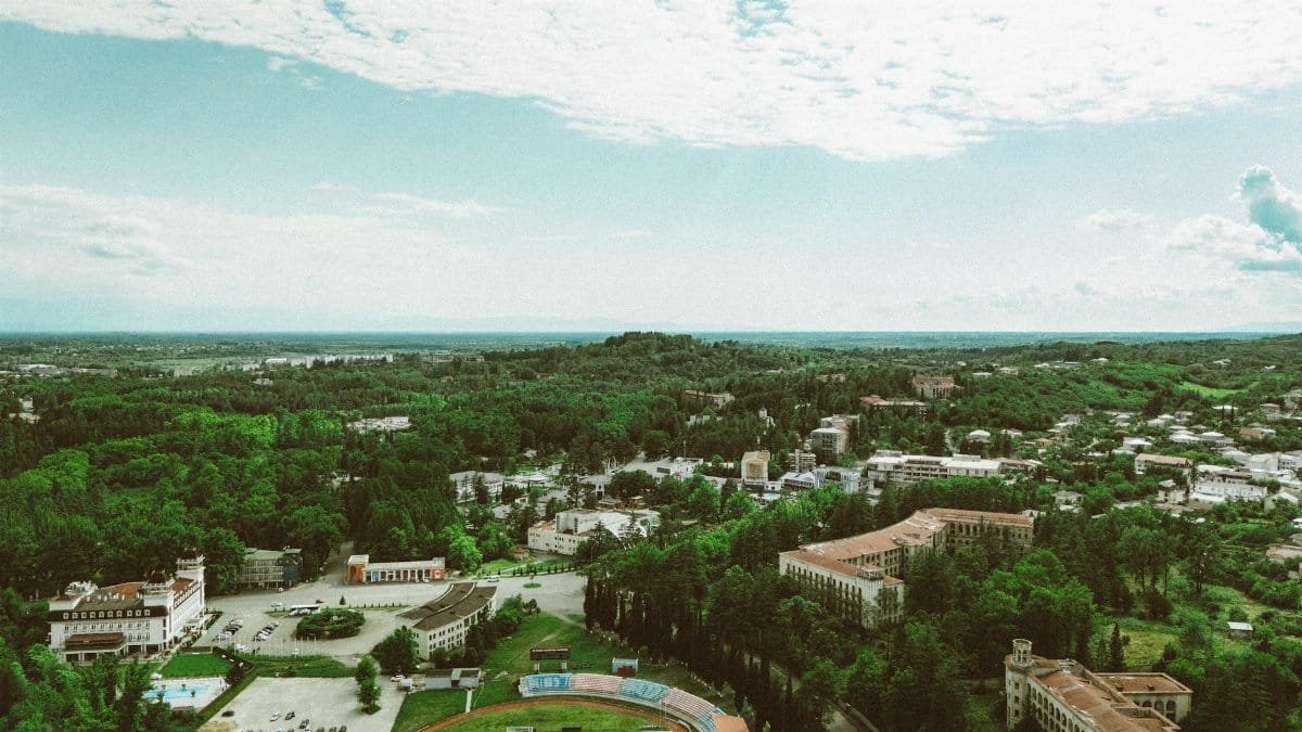Aerial shot of a lush and serene cityscape in Georgia, showcasing green landscapes and architecture.