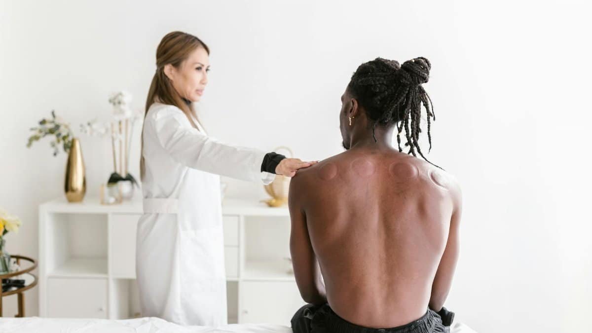 A therapist performs cupping therapy on a man, promoting health and wellness.