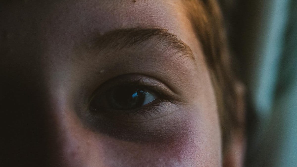A close-up portrait of a child's eye, capturing subtle expressions and natural light details.