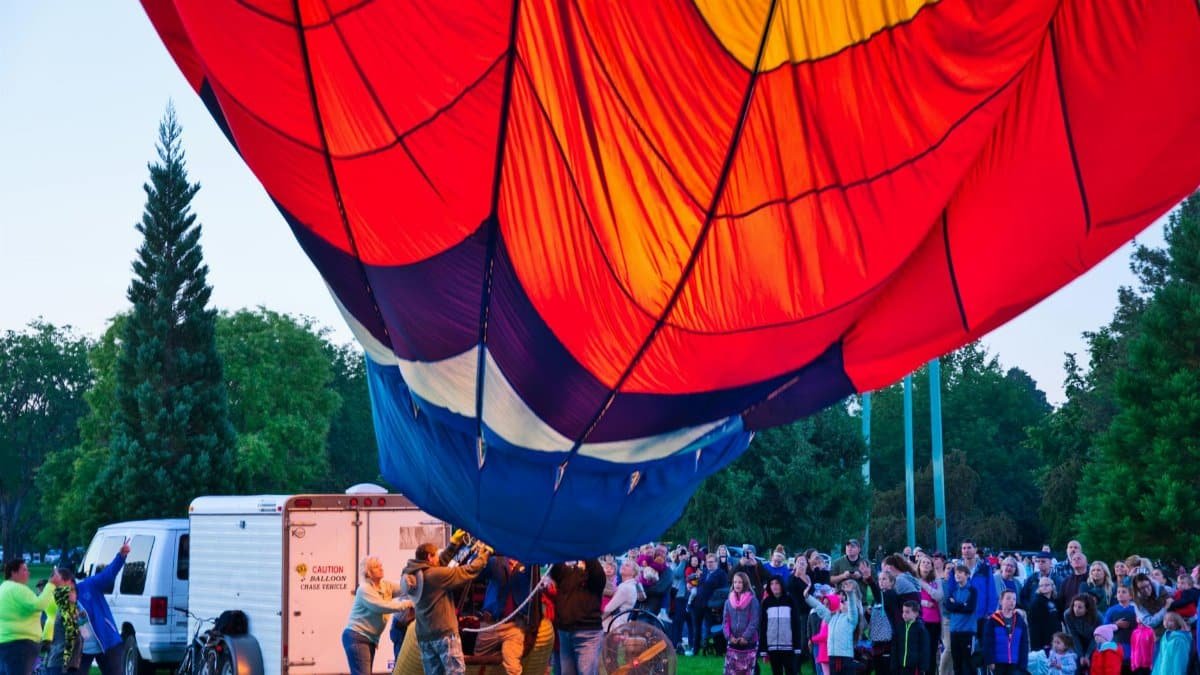 Vibrant hot air balloon launch gathering at a park in Boise, Idaho.