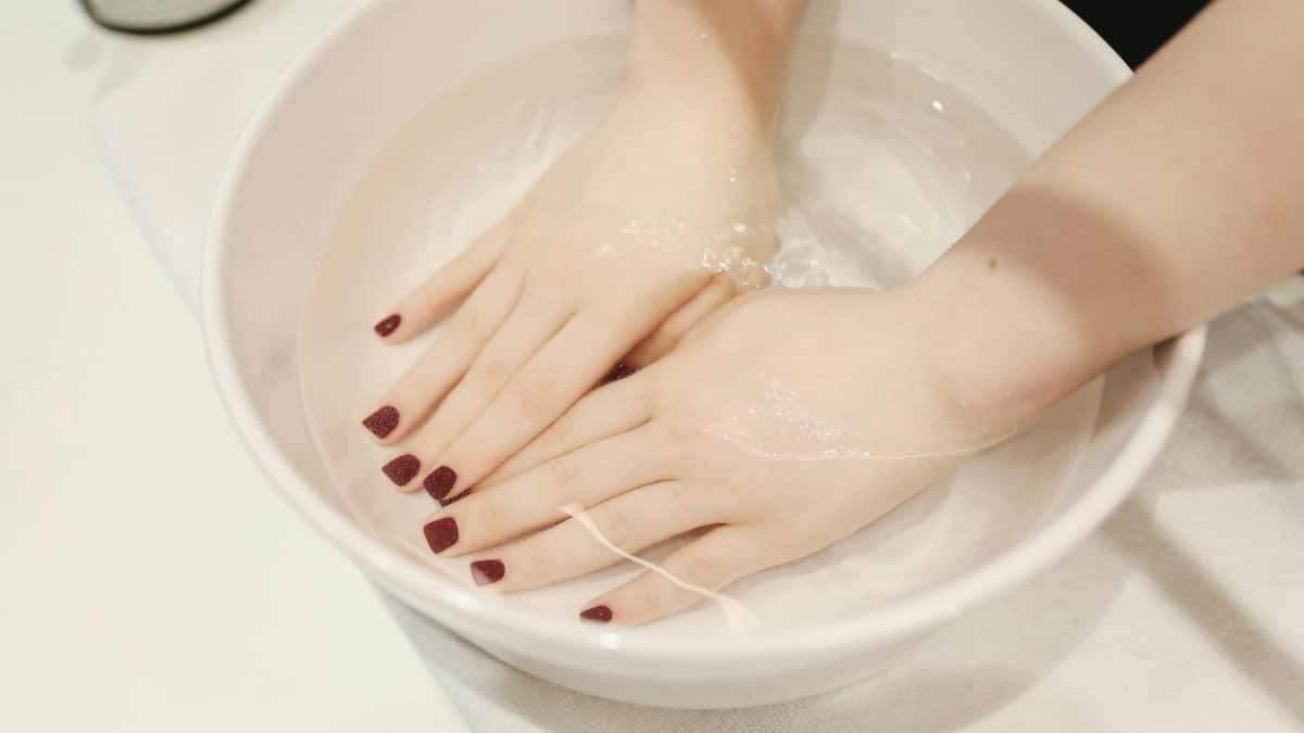 Luxurious hand spa treatment with elegant manicured nails submerged in a soothing soak.