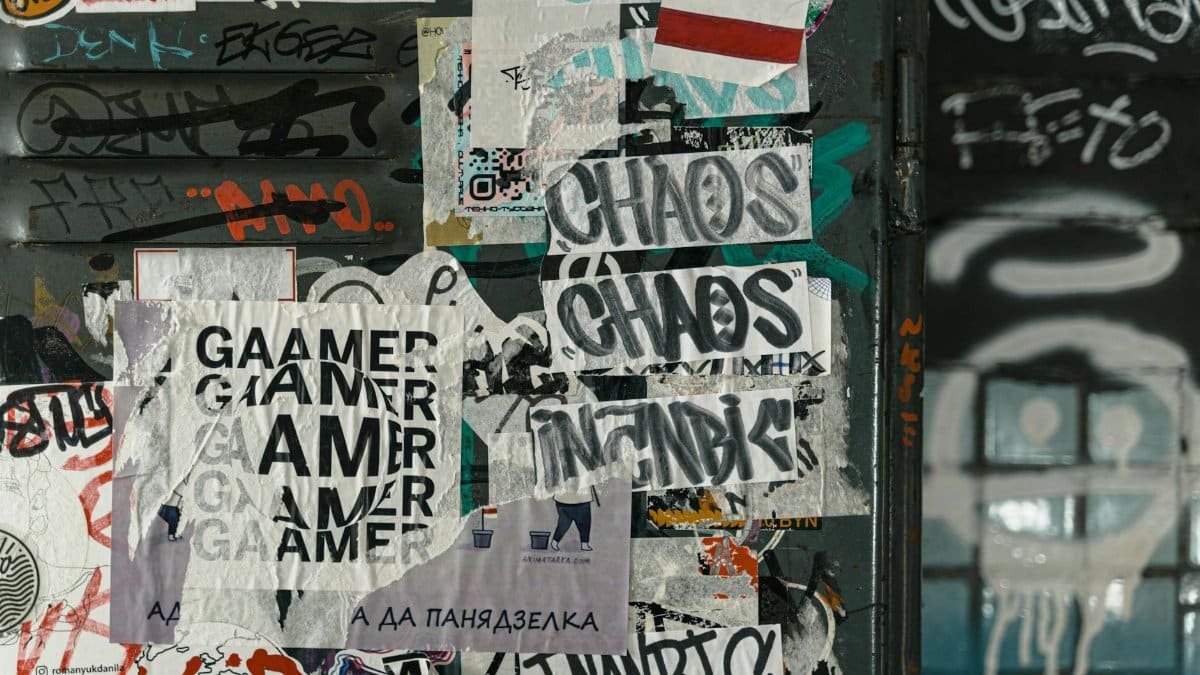 Vibrant urban scene of graffiti and layered posters on a city wall, capturing street art culture.