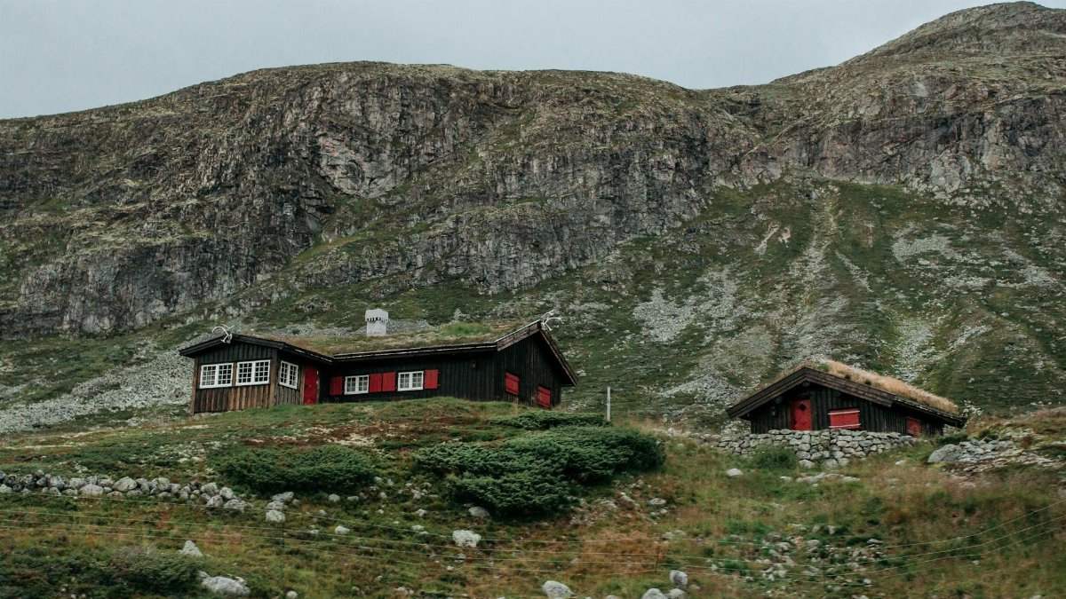 Charming wooden cabins nestled in a lush, rocky mountain region, perfect for a tranquil retreat.