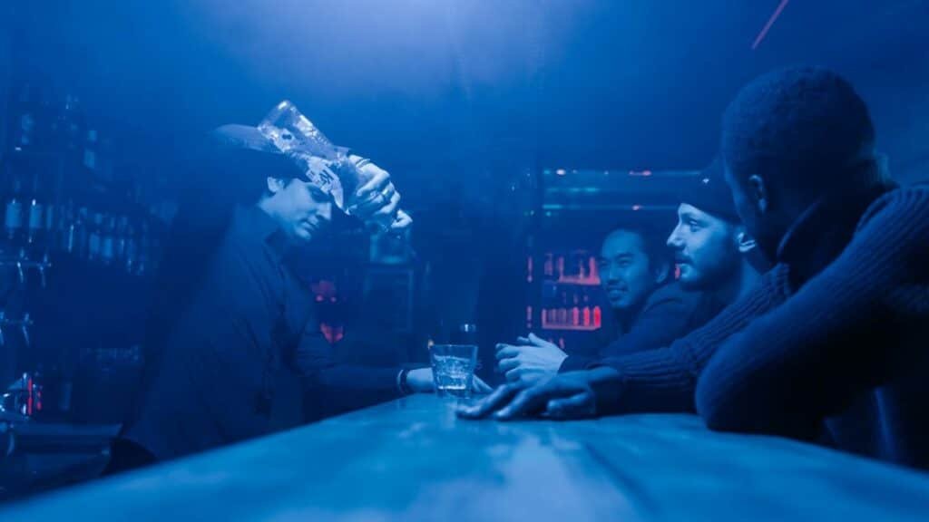 A bartender pours drinks for friends enjoying a night out at a club.