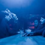 A bartender pours drinks for friends enjoying a night out at a club.