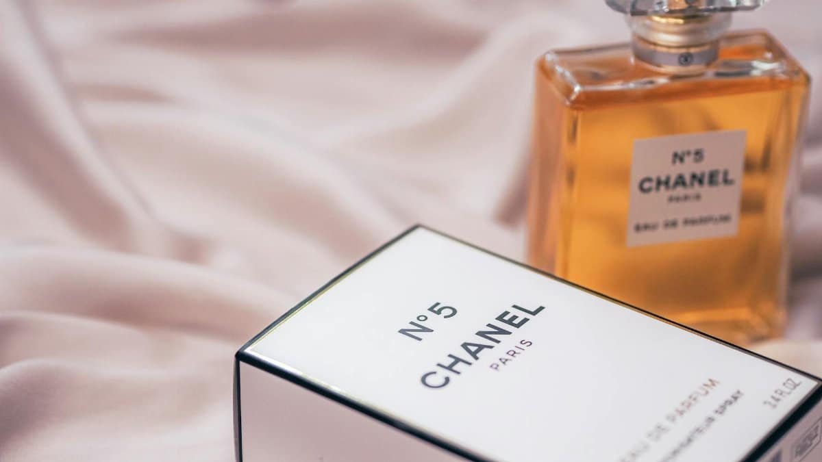 Chanel No.5 perfume bottle with box on soft fabric background in Paris.