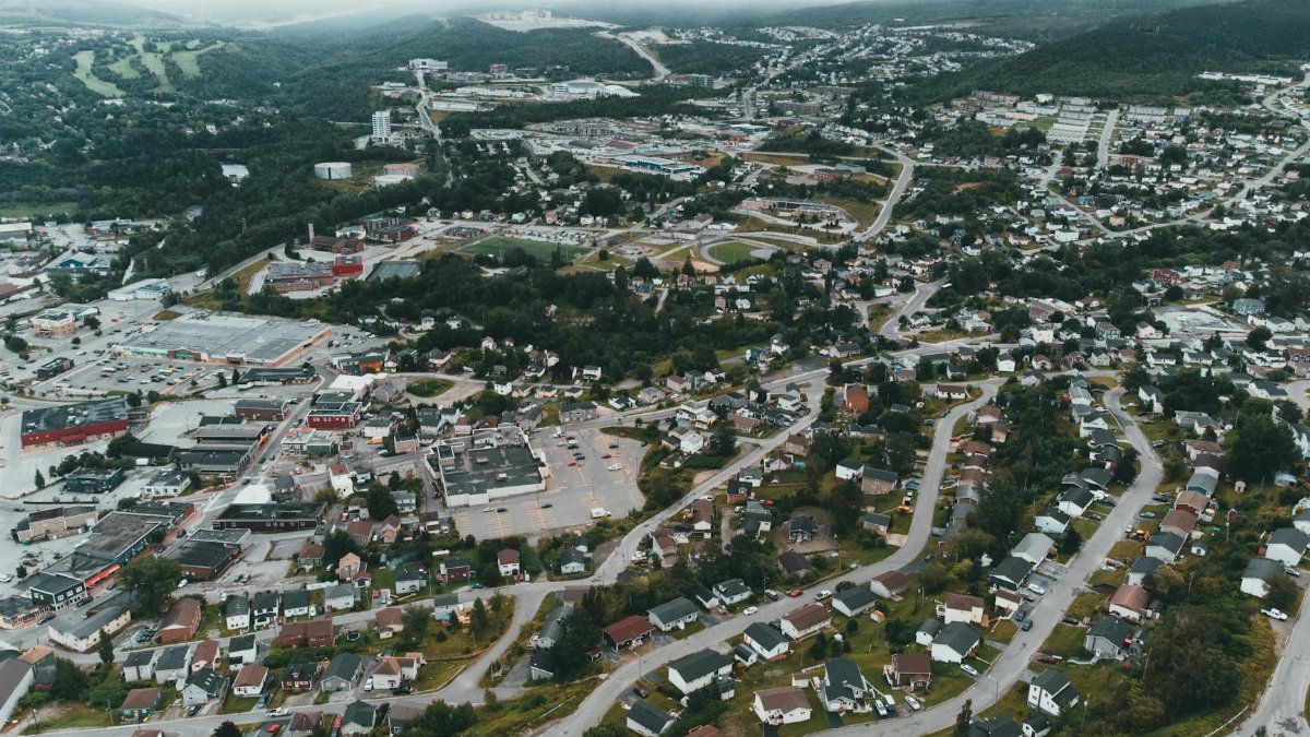 Aerial perspective of a sprawling suburban area surrounded by green landscapes.