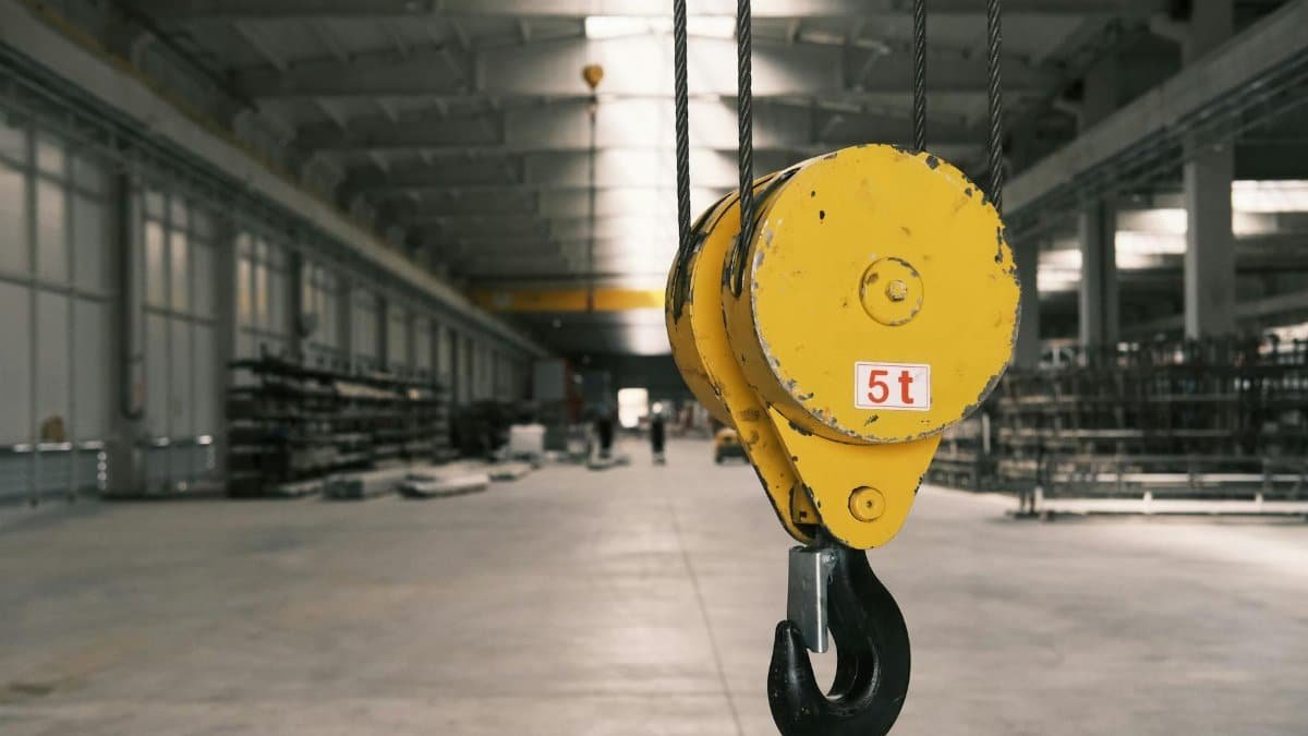 Closeup of a 5-ton yellow crane hook in an empty warehouse in Konya, Türkiye.