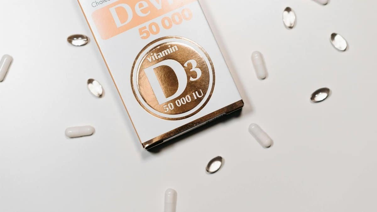 Flat lay of Vitamin D3 supplement box and capsules on a light background.