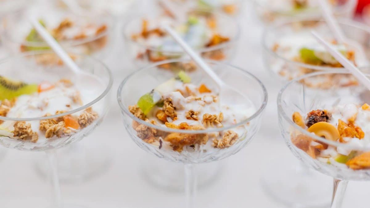 Close-up image of yogurt parfaits with granola and fruit served in elegant glassware for breakfast.