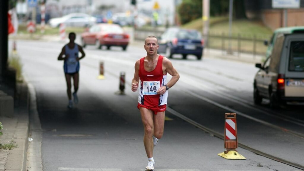 A determined marathon runner in Wrocław competes on an urban street.