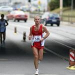 A determined marathon runner in Wrocław competes on an urban street.