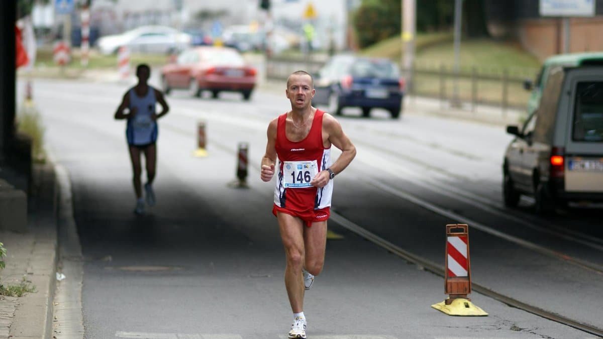 A determined marathon runner in Wrocław competes on an urban street.