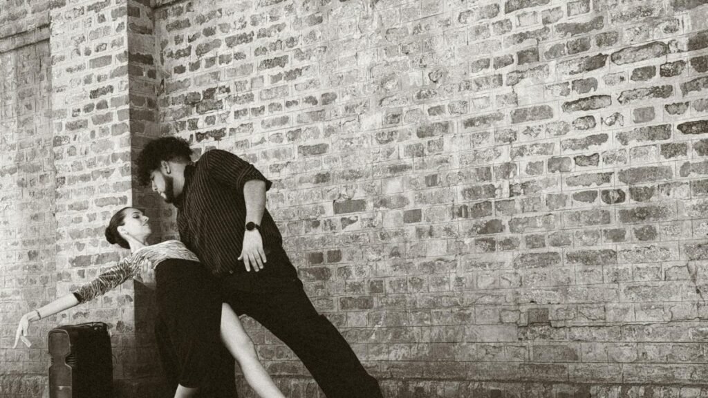 Captivating tango dancers performing in front of a brick wall in Buenos Aires, Argentina.