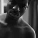 Black and white close-up of a thoughtful man in soft lighting.