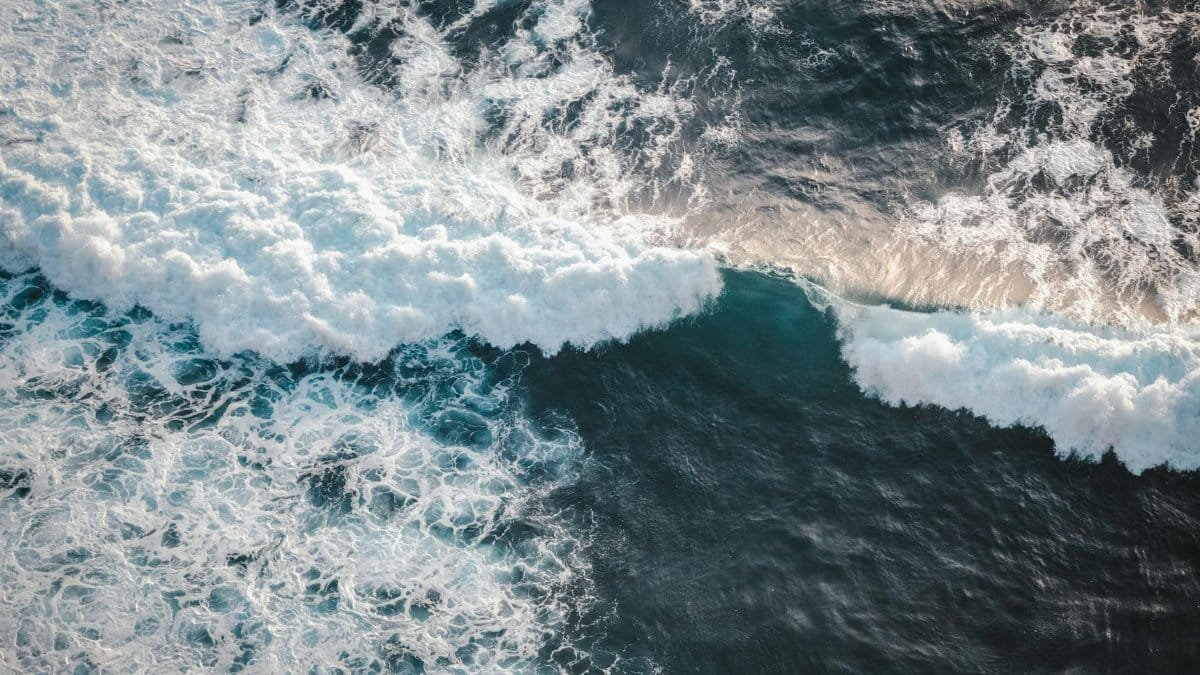Captivating aerial view of ocean waves crashing in Bali, showcasing dynamic energy and natural beauty.