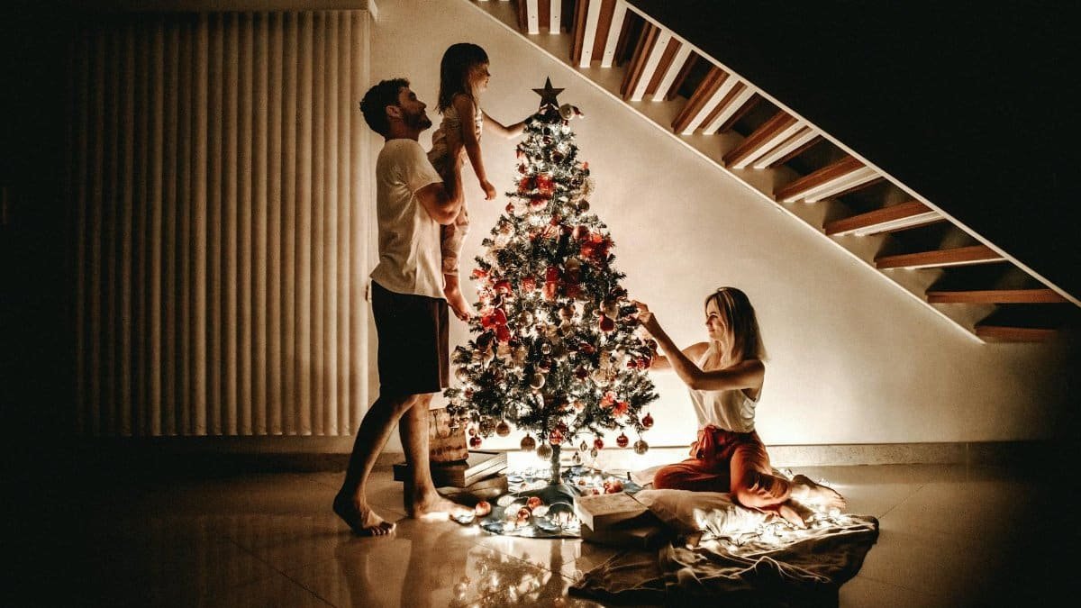A family decorates a Christmas tree, bringing warmth and joy to the holiday season.