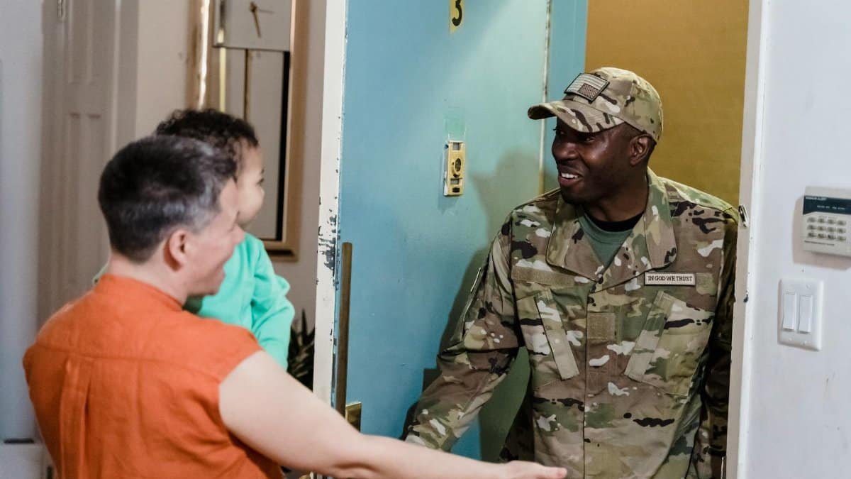 A joyful family reunion at home with a returning soldier greeting loved ones.