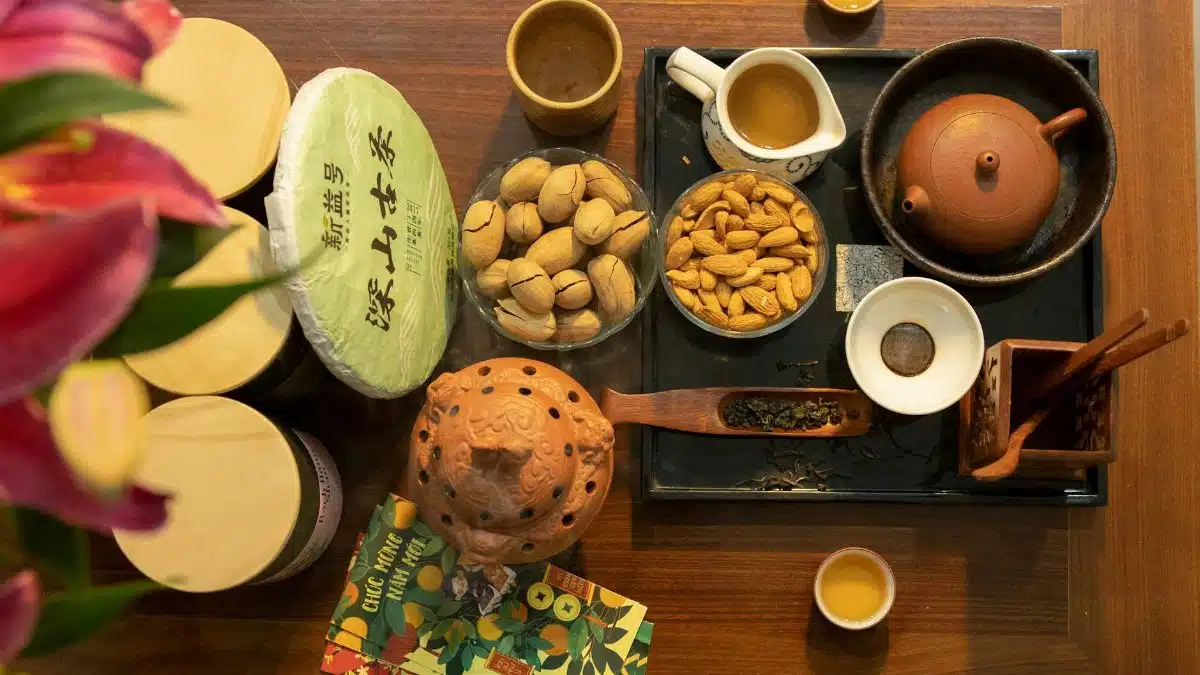 An overhead view of a traditional Chinese tea setting with almonds and nuts, creating a warm and inviting atmosphere.