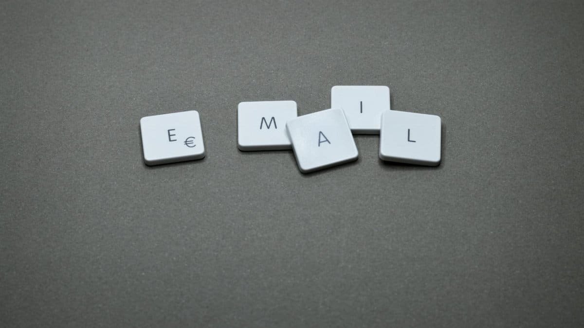 Close-up of the word 'email' formed with letter tiles on a gray surface.