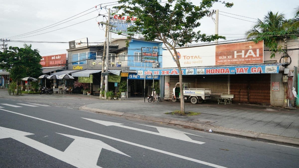 Street scene of local Vietnamese shops and buildings in an urban area.