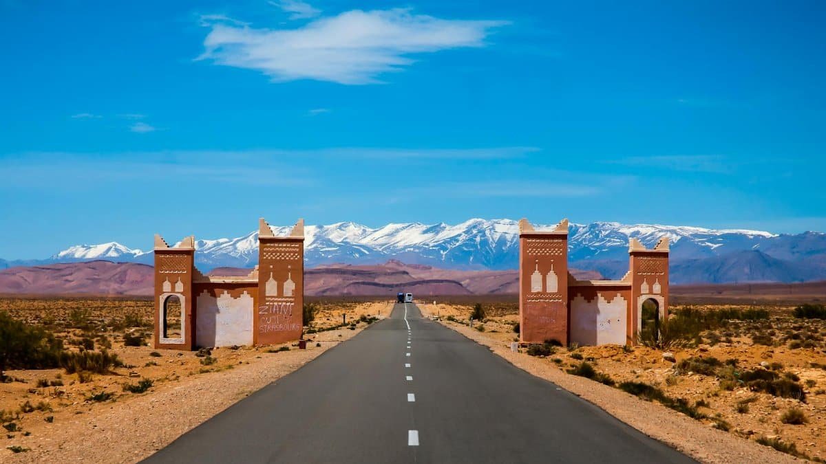 Explore the open road leading to Morocco's Atlas Mountains on a sunny day.