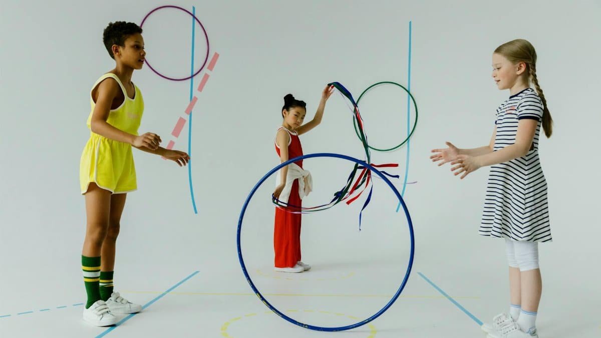 A fun indoor scene with diverse kids playing with colorful hula hoops, emphasizing play and friendship.