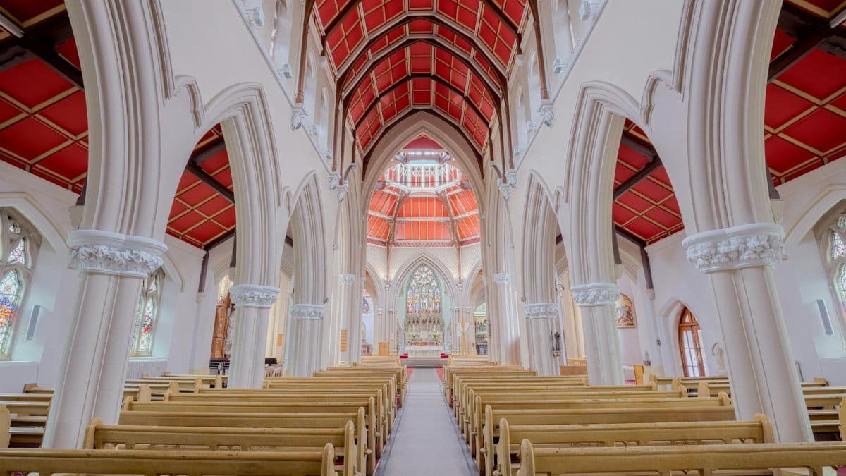 Stunning view of a gothic church interior showcasing intricate arches and red ceilings.